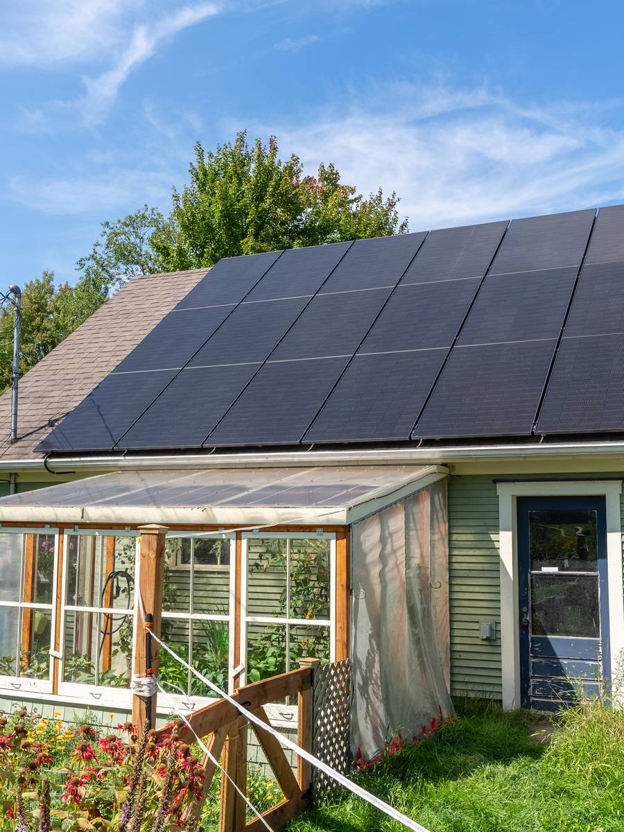 Maison de l'Estrie équipée de panneaux solaires installés par Innovation Solaire Québec, avec sa serre et son jardin.